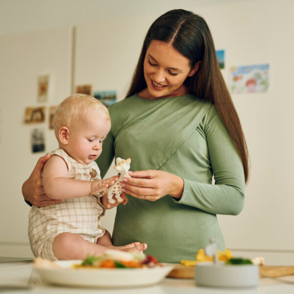 Mutter spielt mit ihrem Baby in der Küche mit der beliebten Giraffe – unbeschwerte Momente ohne Sorgen um Allergien