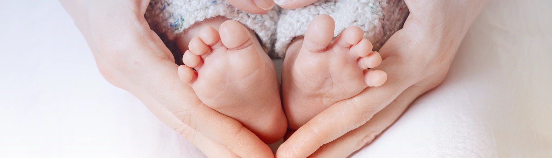 Kleine Babyfüße – zarte Beine eines Neugeborenen