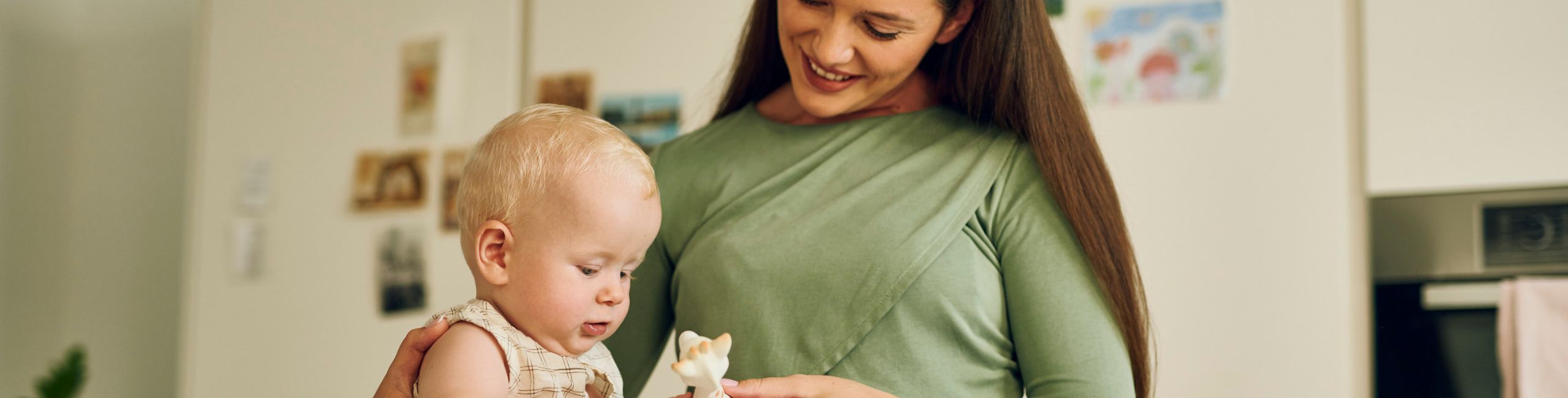 Diese Szene zeigt eine Mutter, die gemeinsam mit ihrem Baby und einer Giraffe spielt – ein liebevoller Moment, der die Bindung stärkt und die Entwicklung des Babys fördert. Spielerische Interaktion unterstützt die motorischen und emotionalen Fähigkeiten und schafft eine warme, sichere Umgebung für das Kind.