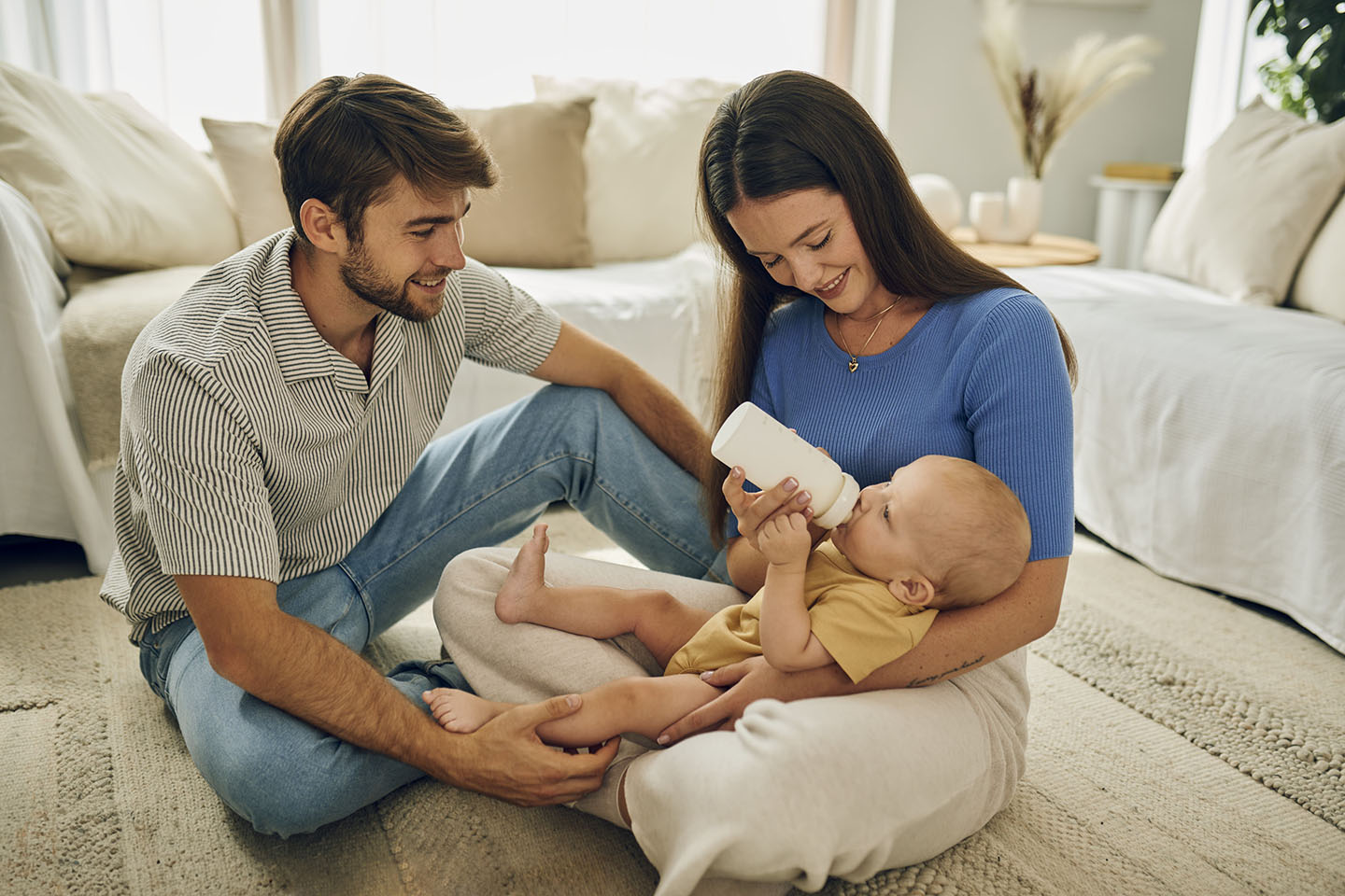 Eltern füttern ihr Baby mit der Novalac Flasche, um es bei Koliken zu unterstützen.