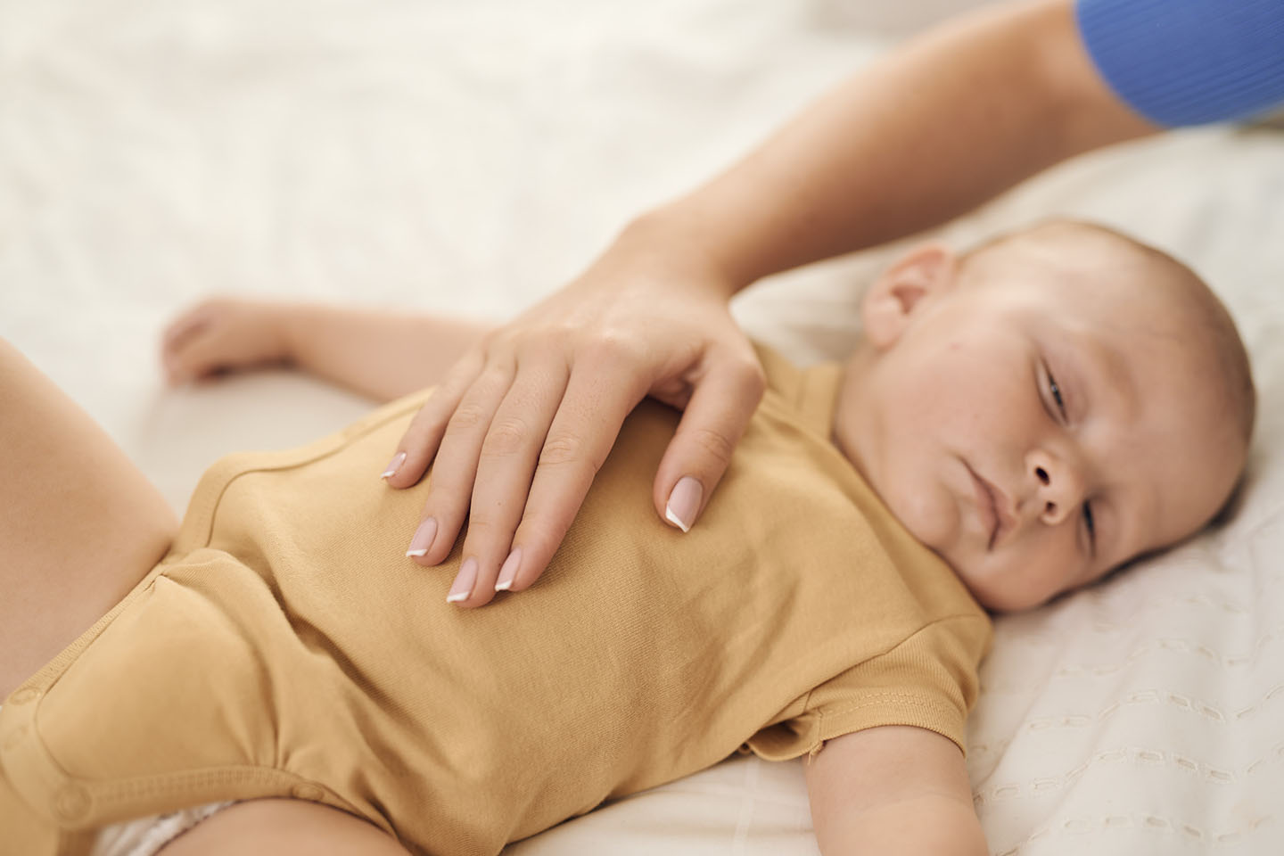 Diese Szene zeigt eine sanfte Bauchmassage bei einem Baby – eine bewährte Methode, um Koliken, Blähungen und Bauchschmerzen zu lindern. Durch leichte, kreisende Bewegungen wird die Verdauung unterstützt und das Wohlbefinden des Babys verbessert. Solche beruhigenden Rituale stärken zusätzlich die Bindung zwischen Eltern und Kind.
