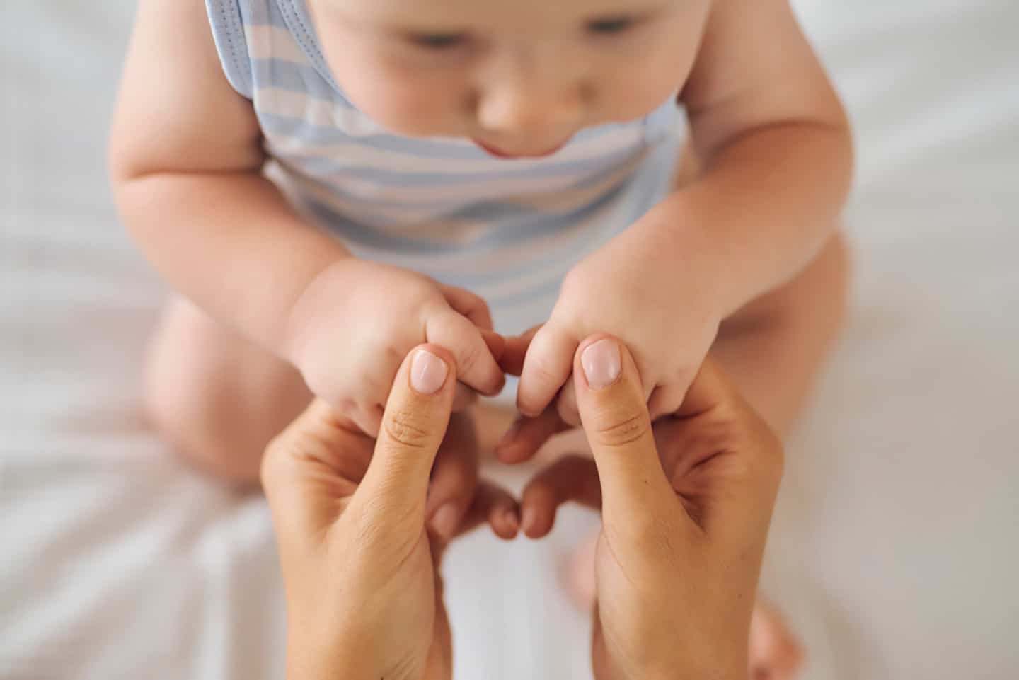Die zarten Hände eines Babys, die Fürsorge und Geborgenheit symbolisieren.