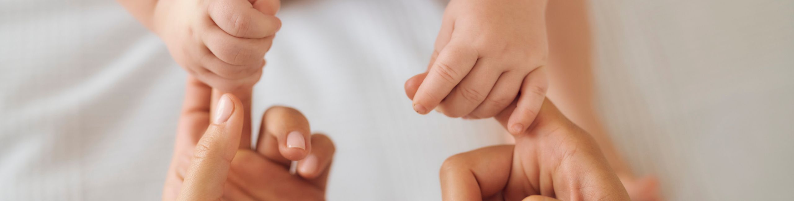 Diese Szene zeigt ein Baby, das die Finger seiner Mutter festhält – ein Moment voller Nähe und Geborgenheit. Gleichzeitig verweist das Motiv auf das Thema Allergien und Laktoseintoleranz im Säuglingsalter. Eine angepasste und gut verträgliche Ernährung ist für betroffene Babys besonders wichtig, um Beschwerden zu vermeiden und die gesunde Entwicklung zu unterstützen.