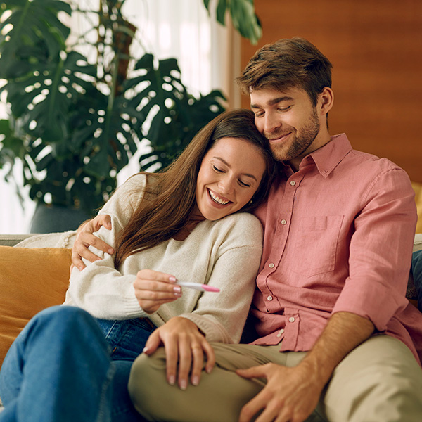 Ein Paar freut sich über den positiven Schwangerschaftstest und beginnt mit der Planung der Schwangerschaft.