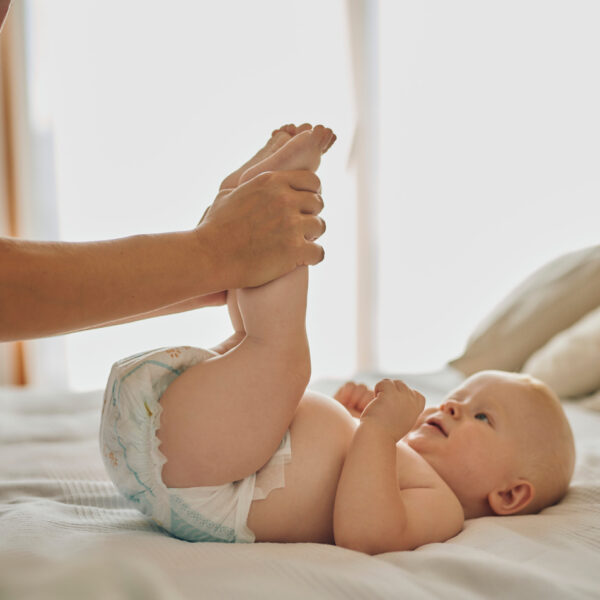 Ein Baby wird sanft gewickelt – ein wichtiger Moment der Pflege und Hygiene.