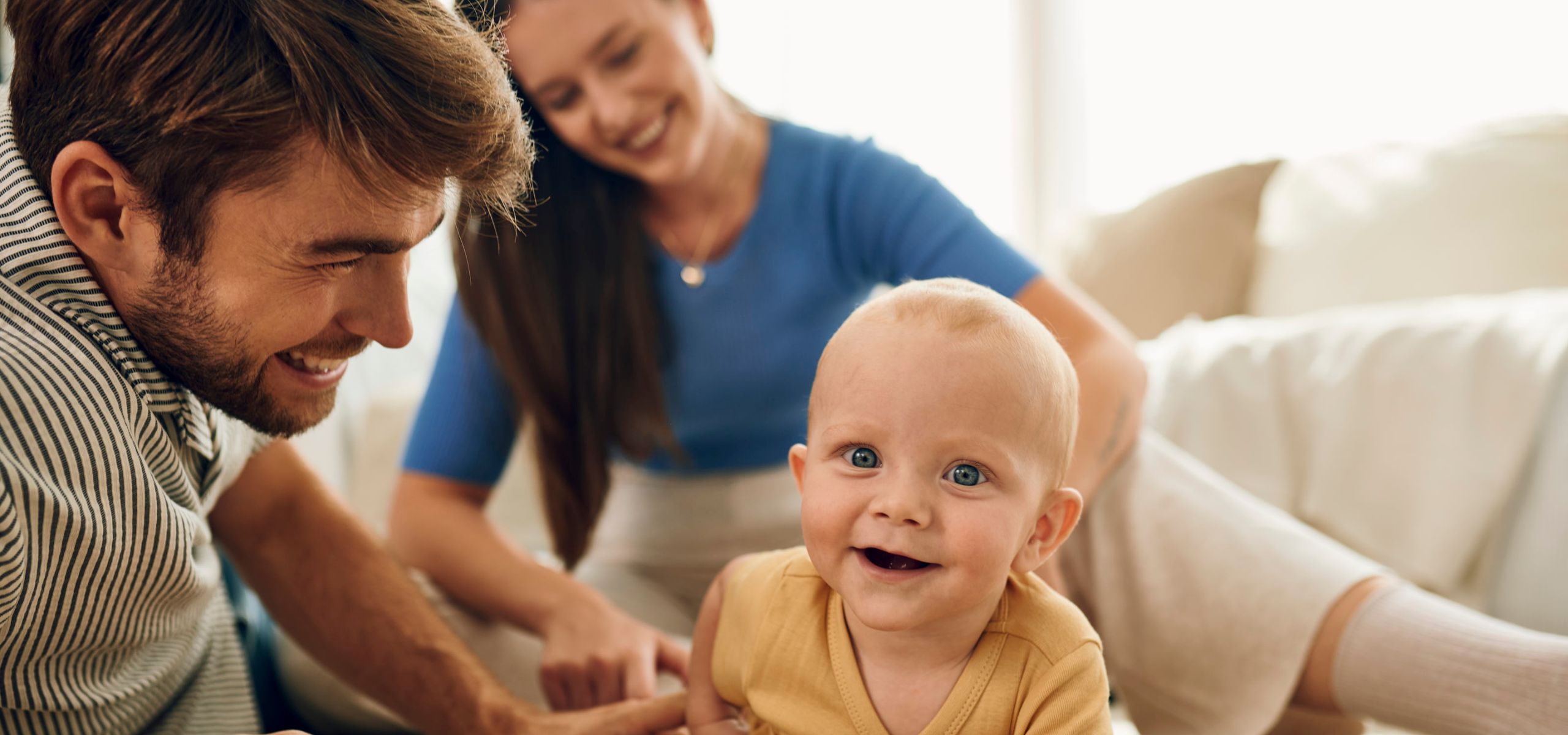 Eine glückliche Familie spielt gemeinsam auf dem Boden im Novalac-Haus.