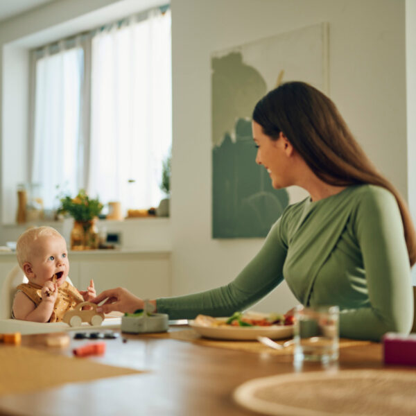 Eine Mutter und ihr Baby genießen zusammen die ersten einfachen Mahlzeiten.