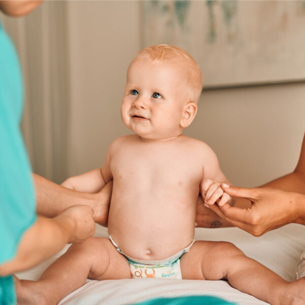 Diese Szene zeigt ein Baby bei einer patronažna sestra, einer Fachkraft für frühe Säuglingsbetreuung. Solche Besuche bieten Eltern Unterstützung, Beratung und Kontrolle der frühen Entwicklung des Babys. Sie helfen, Fragen zu Ernährung, Pflege, Wachstum und Gesundheit sicher zu beantworten und geben Eltern mehr Selbstvertrauen im Alltag mit ihrem Neugeborenen.