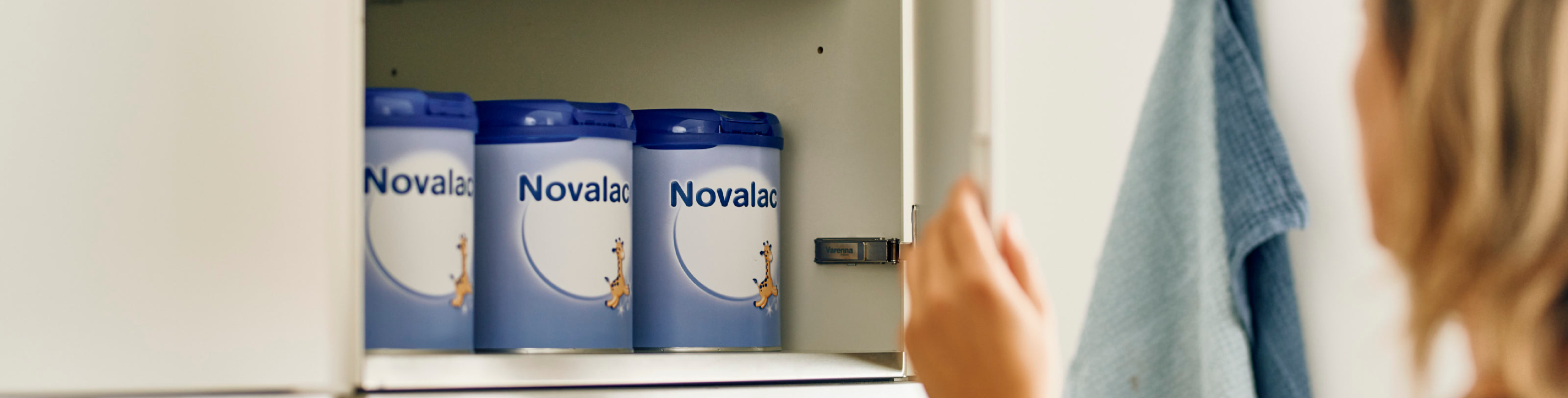 Diese Szene zeigt eine Mutter, die in der Küche nach einer der neatly arrangierten Novalac Milchformeln greift. Die geordnete Ablage vermittelt Übersicht und zeigt, wie wichtig eine zuverlässige, gut verträgliche Säuglingsnahrung im Familienalltag ist. Novalac Formeln unterstützen eine ausgewogene Ernährung und sorgen für sichere, nährstoffreiche Mahlzeiten für Babys jeden Alters.