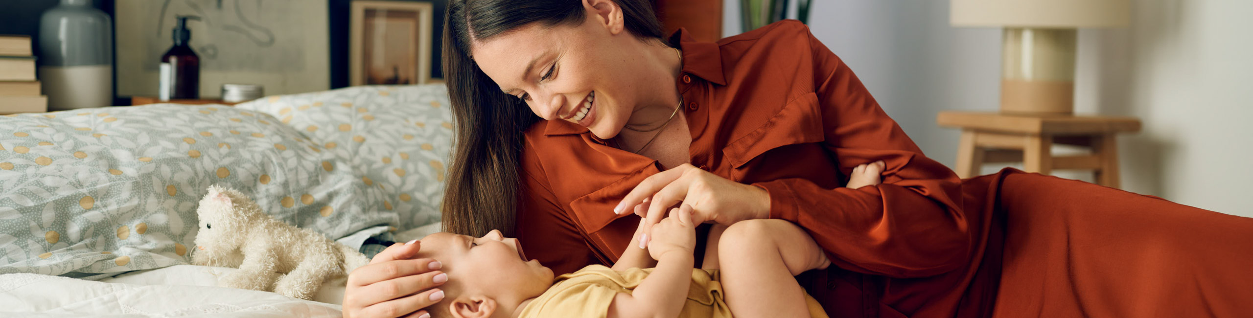 Diese Szene zeigt eine Mutter und ihr Neugeborenes, die sich nach der Geburt liebevoll auf dem Bett anschauen. Solche ersten Blickkontakte stärken die emotionale Bindung, vermitteln Sicherheit und schaffen wertvolle Momente des Ankommens für beide.