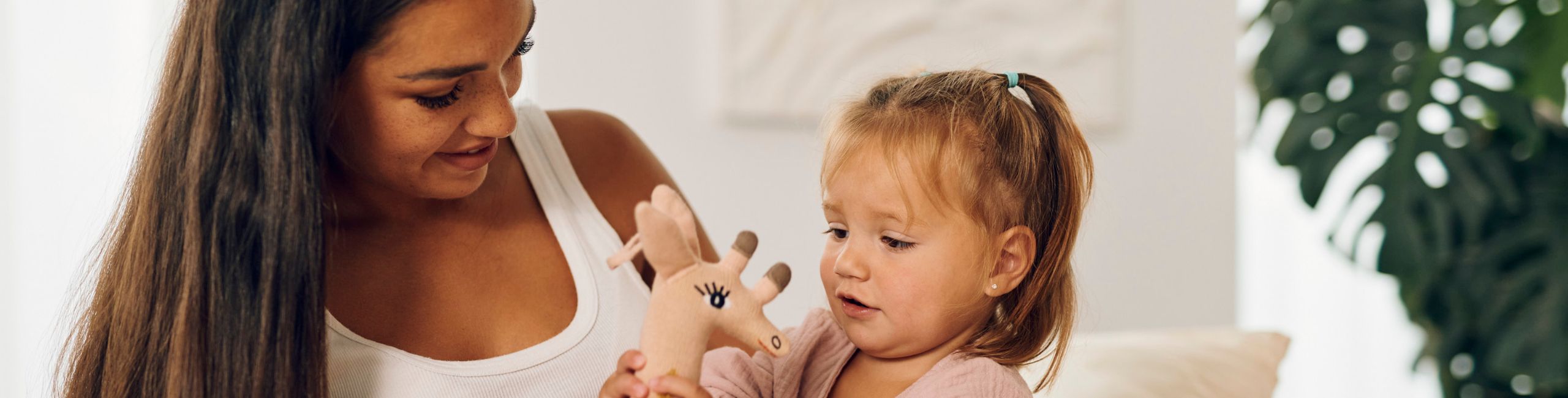 Eine schwangere Mutter und ihr Kind spielen mit einer Giraffe und genießen lehrreiche Momente.