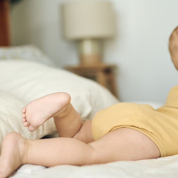 Diese Szene zeigt ein Baby, das auf dem Bett liegt und Anzeichen von Koliken zeigt. Koliken gehören zu den häufigsten Beschwerden in den ersten Lebensmonaten und äußern sich durch Unruhe, Bauchschmerzen und vermehrtes Weinen. Die richtige Ernährung und sanfte Unterstützung können helfen, die Verdauung zu beruhigen und das Wohlbefinden des Babys zu verbessern.