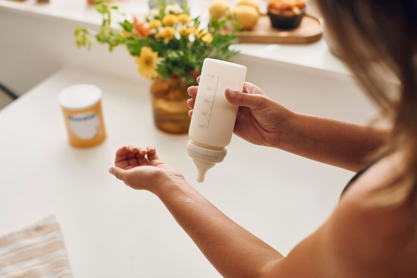 Diese Szene zeigt eine Mutter, die in der Küche eine Milchflasche vorbereitet – ein entscheidender Schritt für Babys mit einer Allergie gegen Kuhmilcheiweiß. Die richtige Auswahl einer verträglichen Spezialnahrung hilft, Beschwerden zu vermeiden und das Wohlbefinden des Babys zu fördern. Eine sorgfältige Zubereitung sorgt dafür, dass das Kind sicher und optimal versorgt wird.