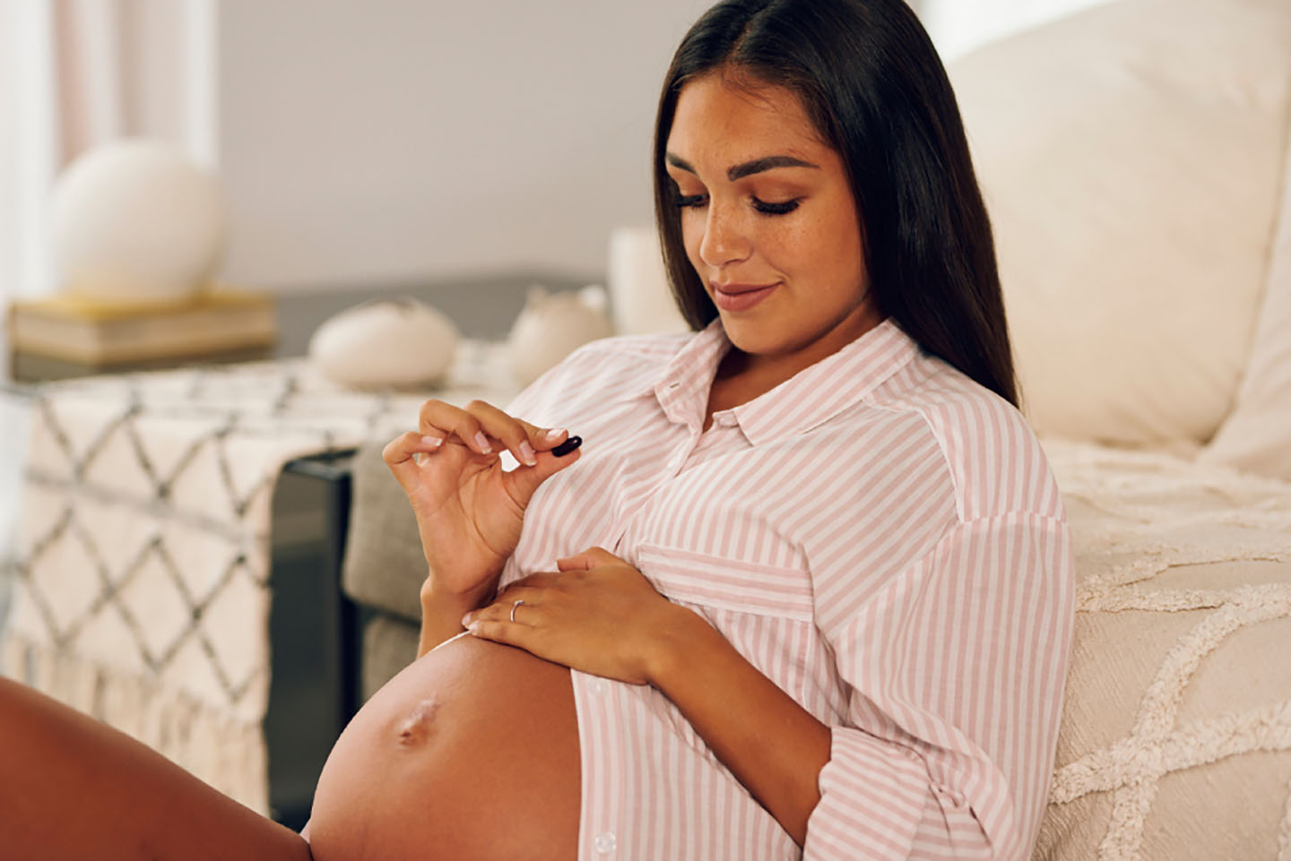 Diese Szene zeigt eine schwangere Frau, die Novalac Prenatal Kapseln einnimmt, um ihren täglichen Bedarf an wichtigen Nährstoffen zu decken. Die Kombination aus aktiver Folsäure (Quatrefolic®), sanftem Lipofer®-Eisen und DHA unterstützt die gesunde Entwicklung des Babys und das Wohlbefinden der werdenden Mutter. Novalac Prenatal ist eine ideale Ergänzung für eine ausgewogene Schwangerschaftsvorsorge.